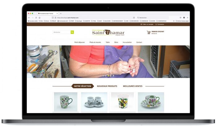 Montage de la page d’accueil de la boutique Porcelaines Saint-Thamar affichée sur un ordinateur portable Apple, présentant des pièces en porcelaine décorées à l’or 24 carats et au platine