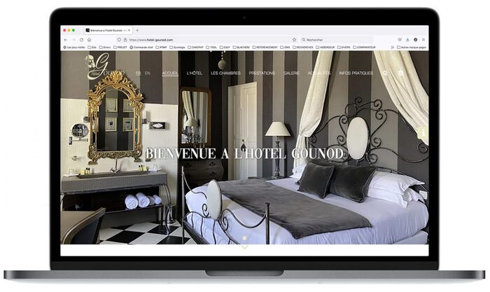 Montage de la page d’accueil du site Hôtel Gounod affiché sur un ordinateur portable Apple, présentant les chambres, le jardin et le charme provençal de l’établissement