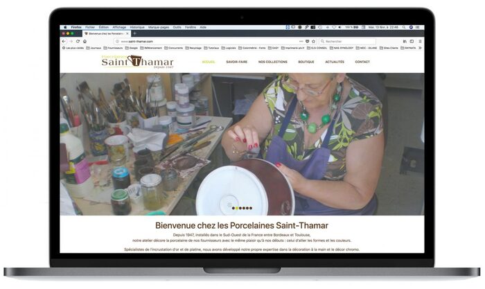 Visuel du site des Porcelaines Saint-Thamar affiché sur un ordinateur portable Apple, présentant ses créations artisanales en porcelaine décorée à la main