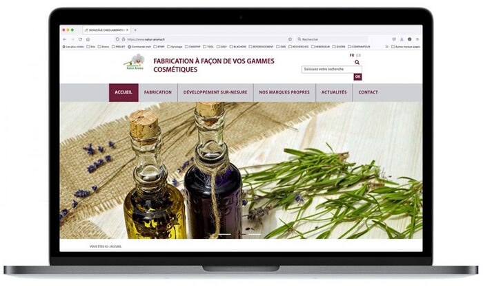Montage de la page d’accueil du site Natur Aroma sur un ordinateur portable Apple, présentant les gammes d’huiles essentielles et hydrolats du laboratoire