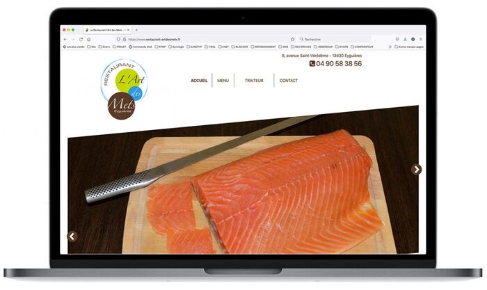 Visuel du site du Restaurant Art des Mets affiché sur un ordinateur portable Apple, présentant sa cuisine raffinée et son univers gastronomique